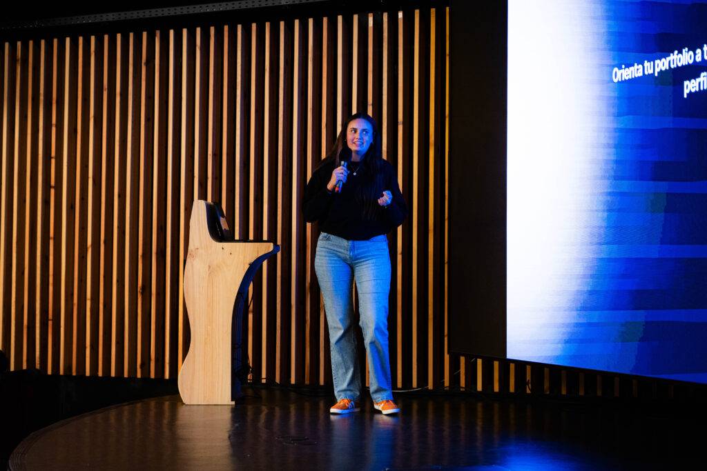 Una persona está presentando en un escenario con un micrófono en la mano.