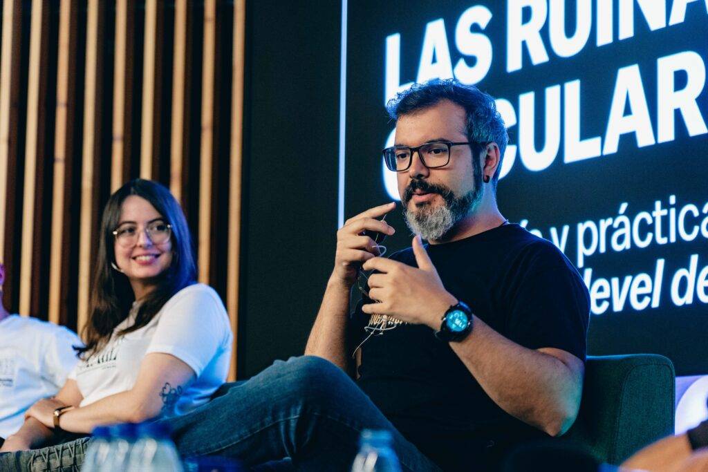 Una charla en un evento sobre las ruinas populares con dos ponentes sentados en un escenario.