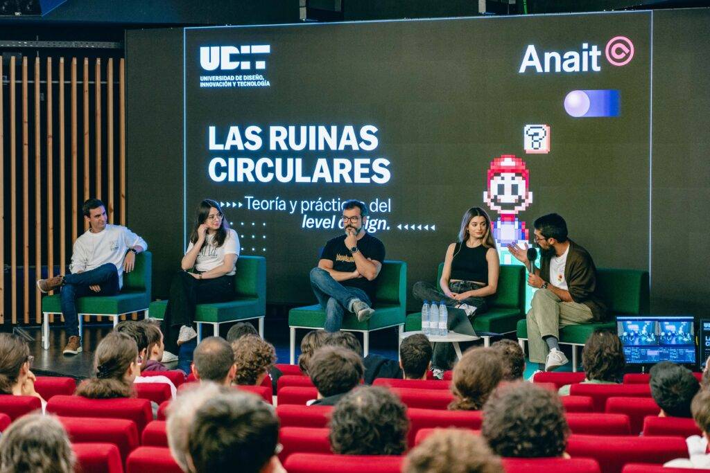 Un panel de discusión sobre teoría y práctica del diseño de niveles en un auditorio con un gran público.