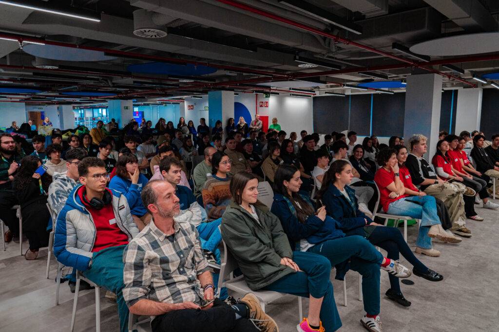 Un grupo de personas sentadas en un auditorio durante un evento.