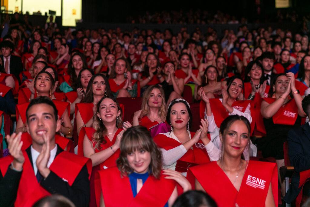 Un grupo de graduados aplaudiendo en una ceremonia de graduación.