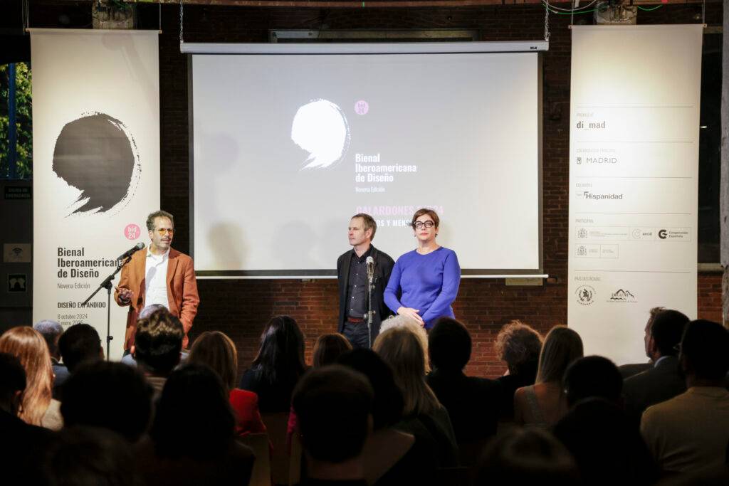Un grupo de personas en un evento de la Bienal Iberoamericana de Diseño en un ambiente interior.