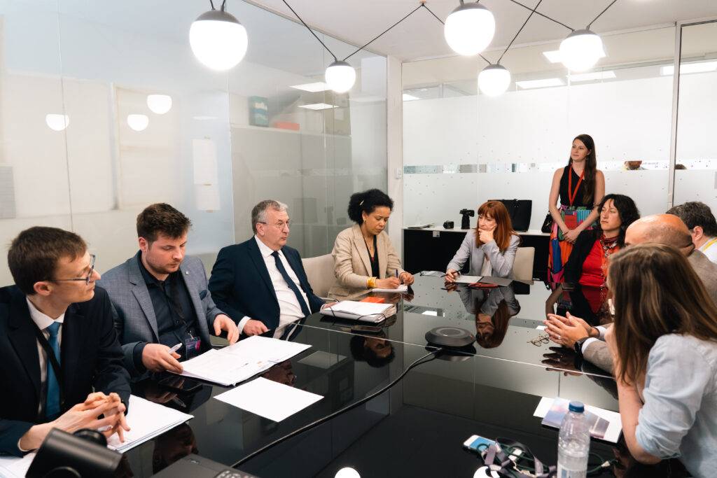 Un grupo de personas sentadas alrededor de una mesa en una reunión de trabajo.