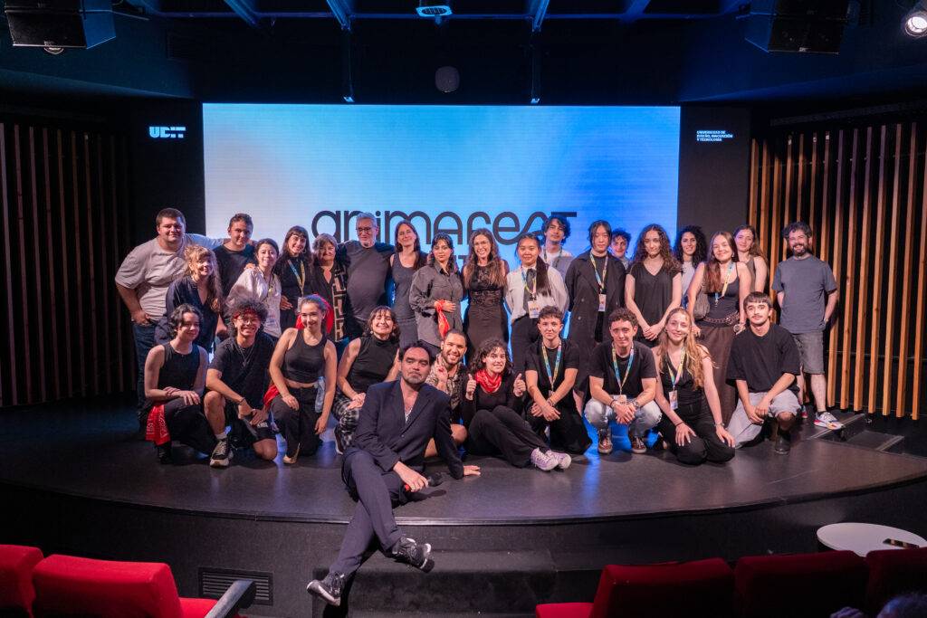 Un grupo de personas posando juntas en un escenario durante un evento de animación.