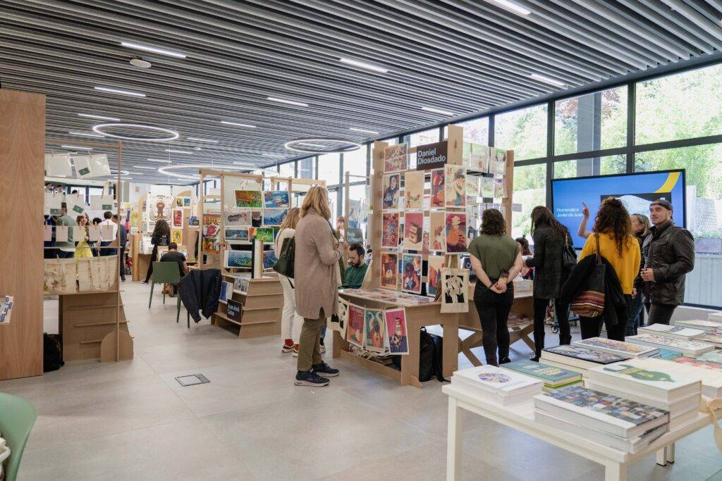 Una moderna librería con mesas de exhibición y personas explorando libros y revistas.