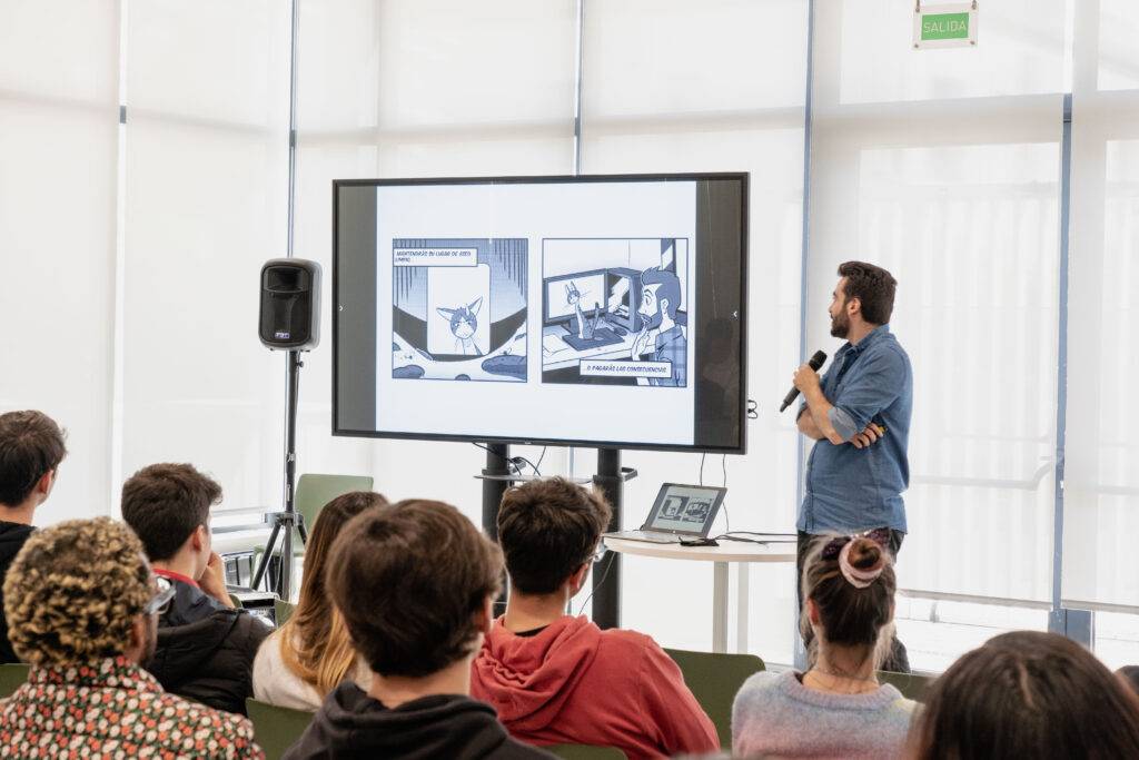 Una persona presenta contenido visual en una pantalla a un grupo de espectadores.