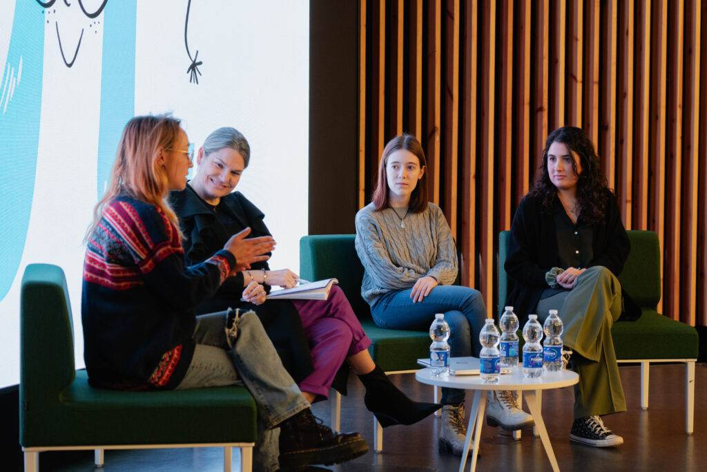 Un panel de cuatro mujeres discutiendo en un evento o conferencia.