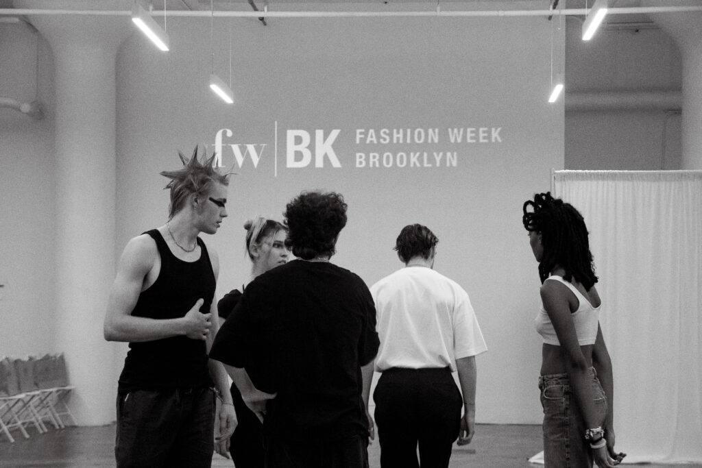 Un grupo de personas con estilos diversos se reúne en un salón de moda durante la Semana de la Moda de Brooklyn.