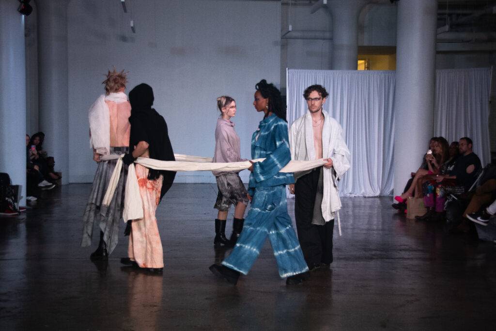 Una pasarela de moda con varios modelos vistiendo ropa contemporánea.