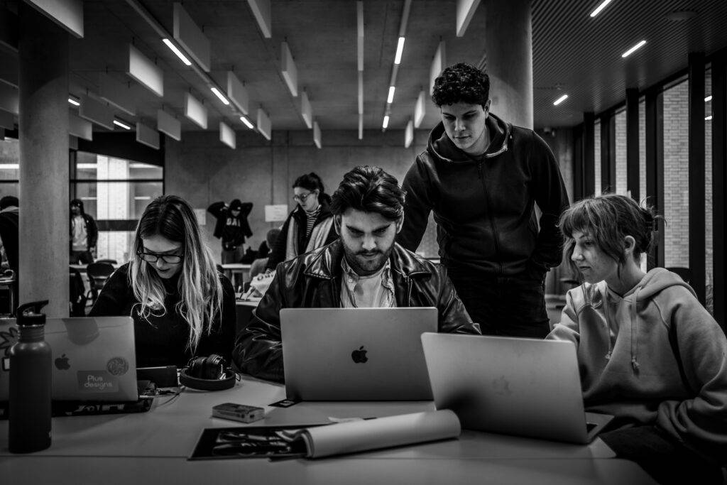 Un grupo de estudiantes trabajando en sus computadoras en un ambiente colaborativo.