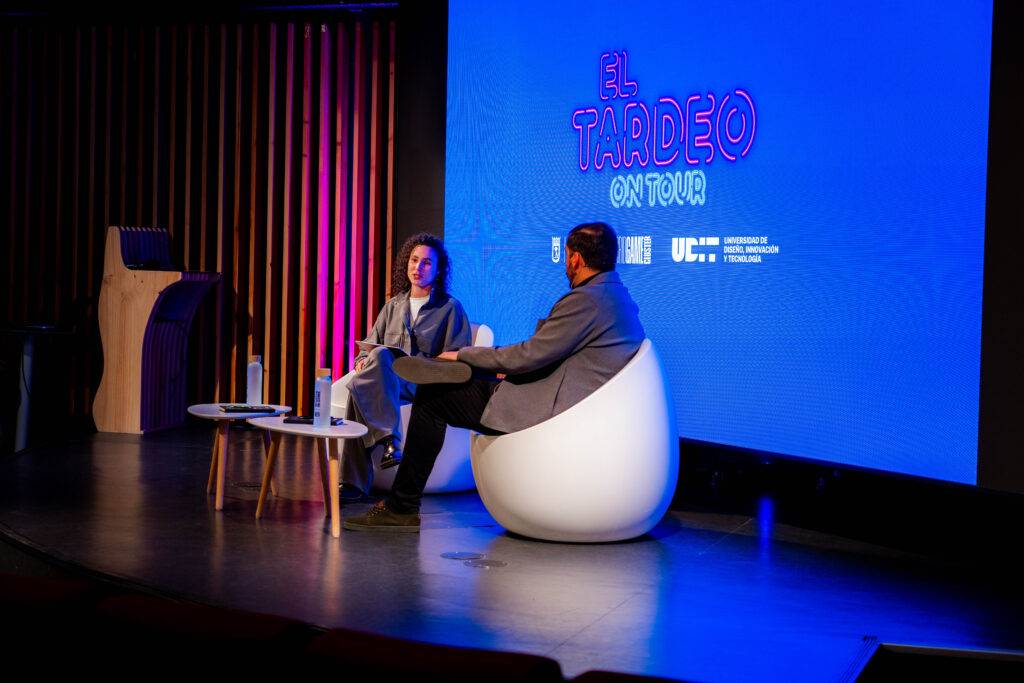 Un evento en el que dos personas están sentadas en un escenario hablando frente a una audiencia.