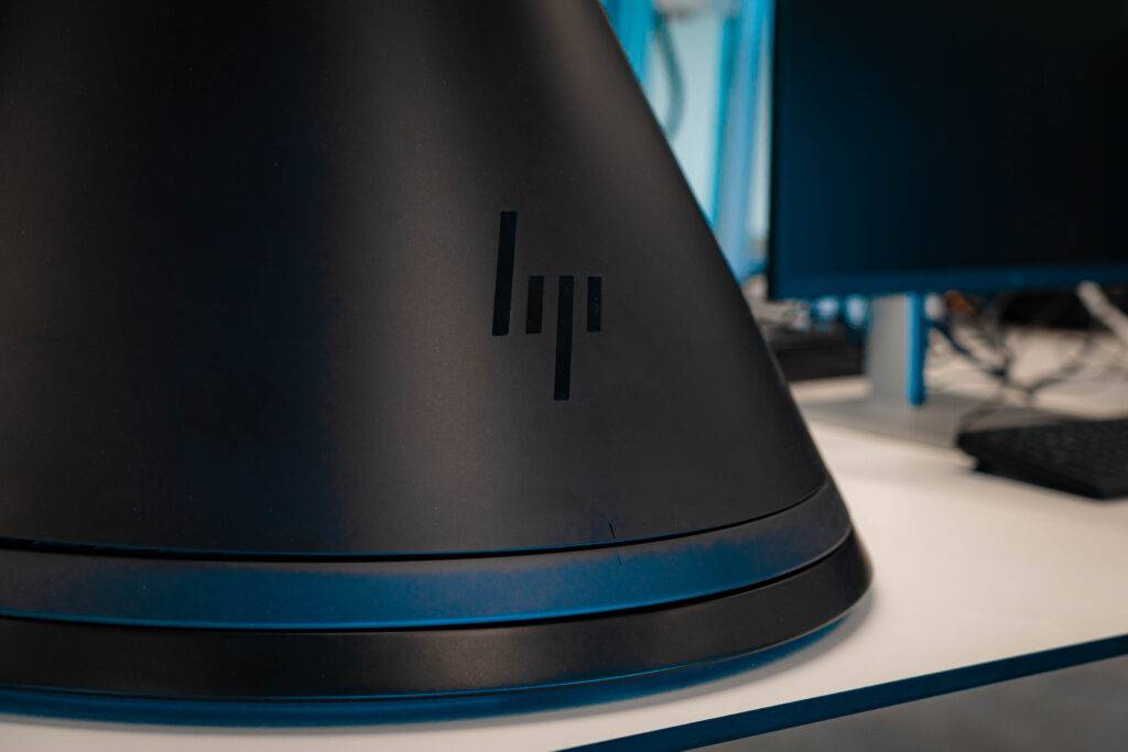 Una parte de un dispositivo con el logotipo de HP en un entorno de oficina.