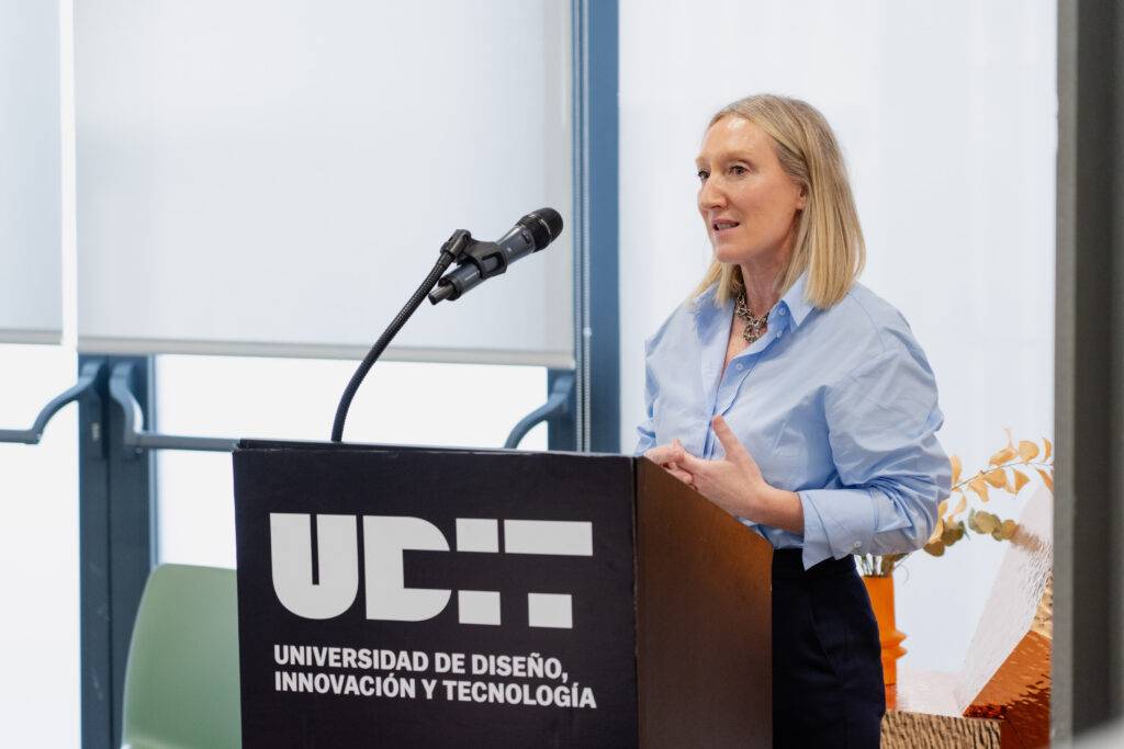 Una mujer habla en un podio de la universidad, en un evento relacionado con diseño e innovación.
