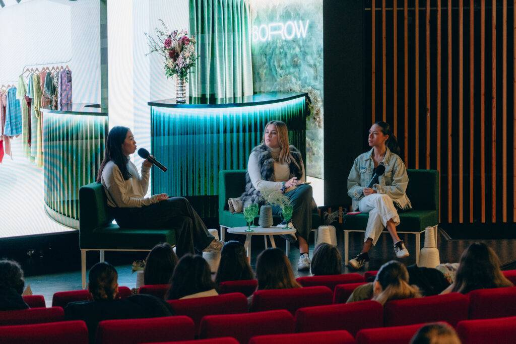 Tres mujeres participan en una charla sobre moda en un entorno moderno y elegante.