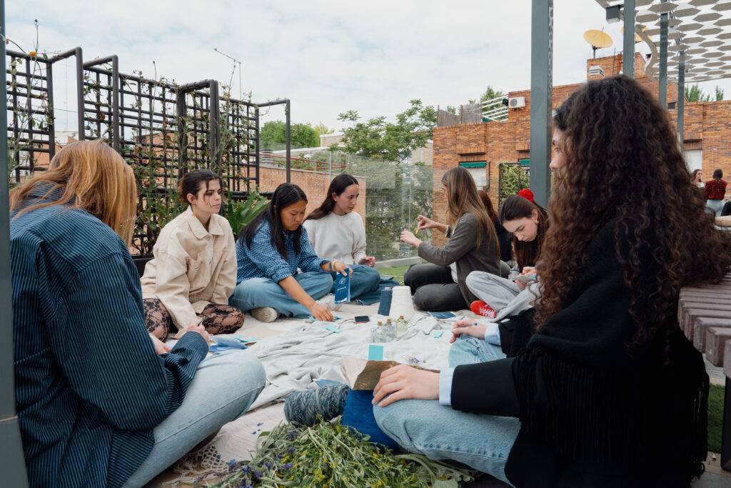 Un grupo de personas se reúne en un espacio al aire libre para participar en una actividad creativa.