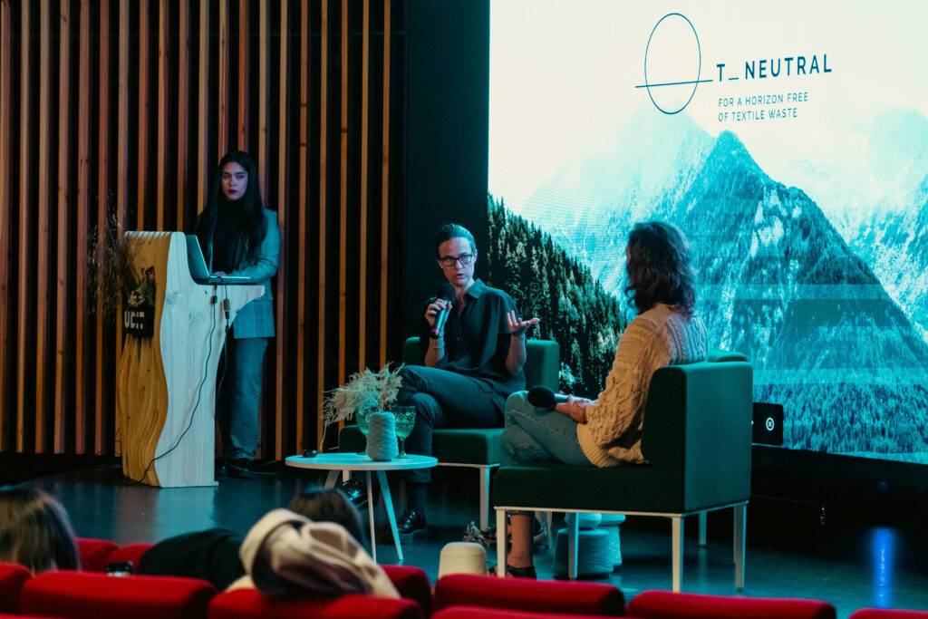 Mesa redonda sobre sostenibilidad en un evento con un público interesado.