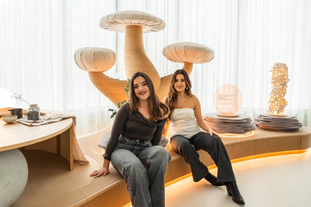 Dos mujeres posan en un ambiente moderno y minimalista con elementos decorativos de diseño.