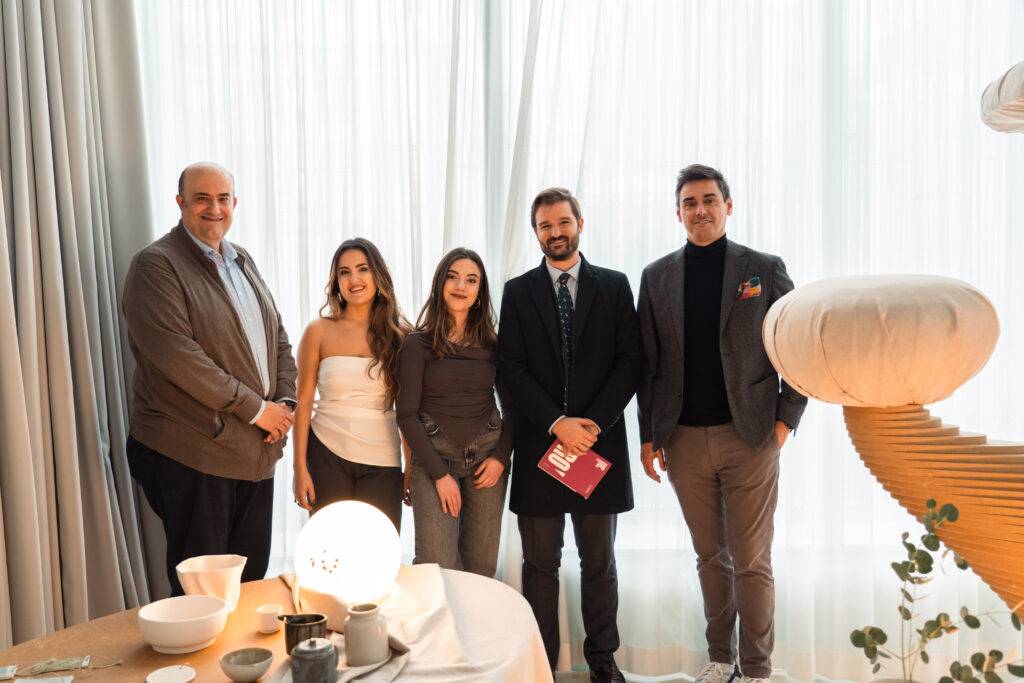 Un grupo de cinco personas posan juntas en un ambiente elegante y moderno, rodeados de decoración contemporánea.