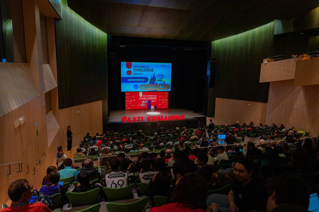 Una sala de conferencias llena de asistentes durante un evento de presentación.