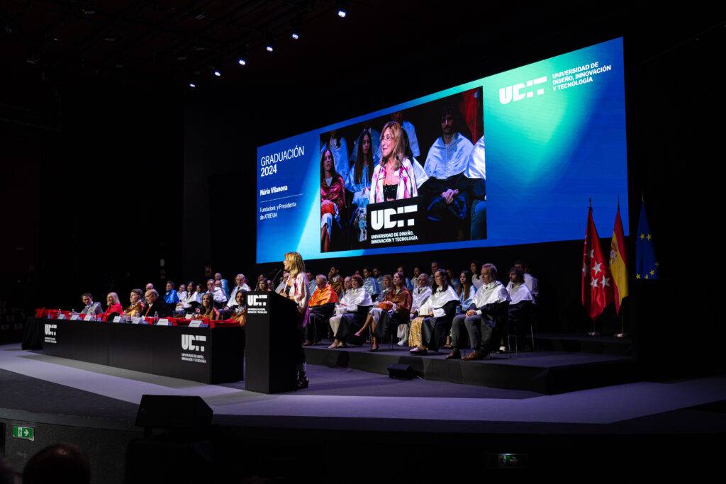 Ceremonia de graduación con un orador en el podio y una audiencia visible.