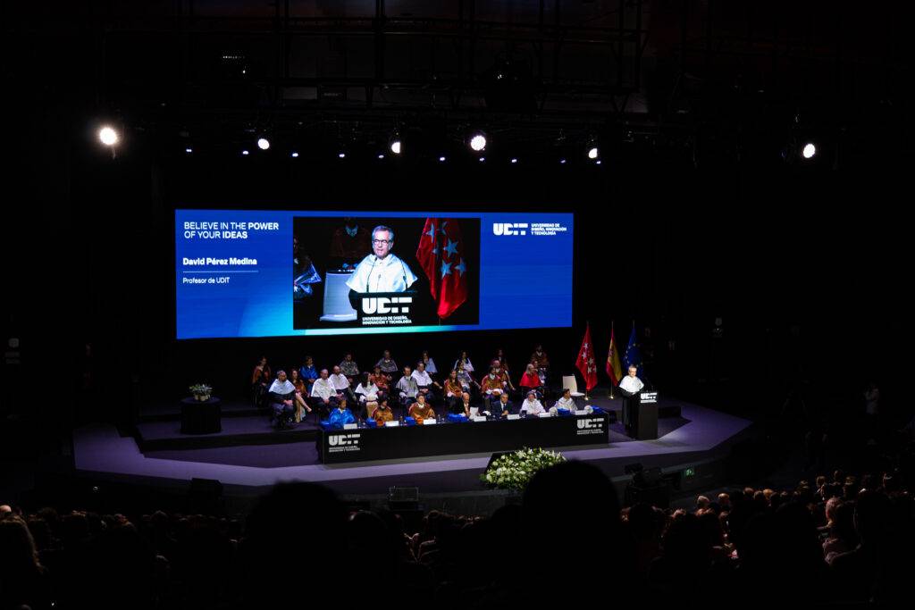 Una ceremonia en un escenario con una presentación visual y un orador al frente.