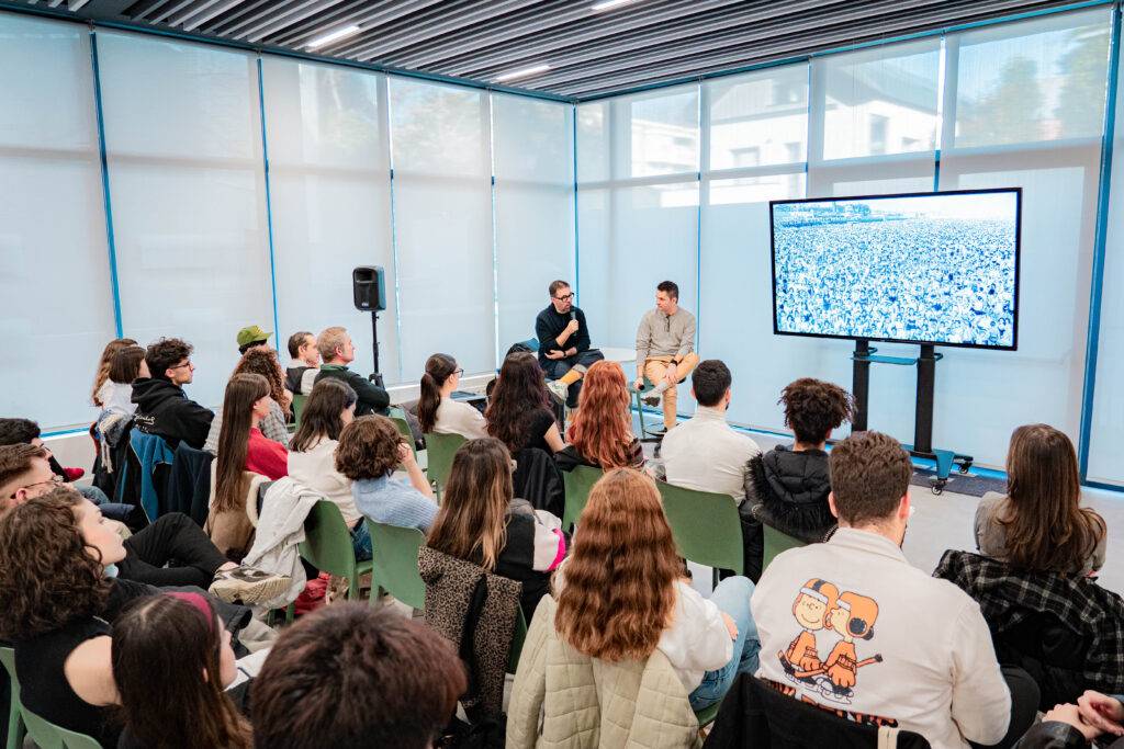 Un grupo de personas asiste a una charla mientras observan una presentación en pantalla.