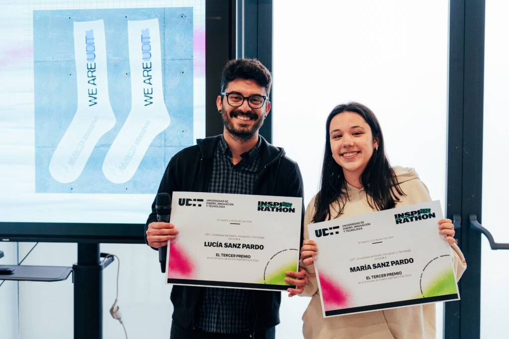 Dos personas sostienen certificados en un evento de premiación.