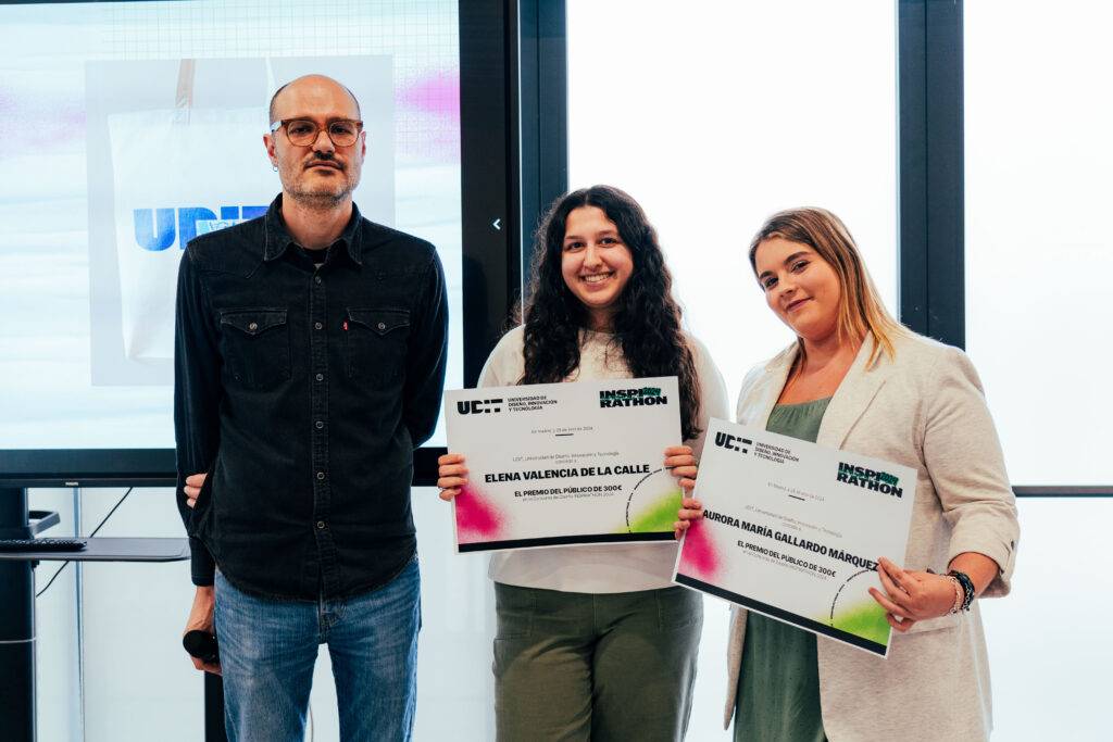 Tres personas posan sosteniendo diplomas en un evento.