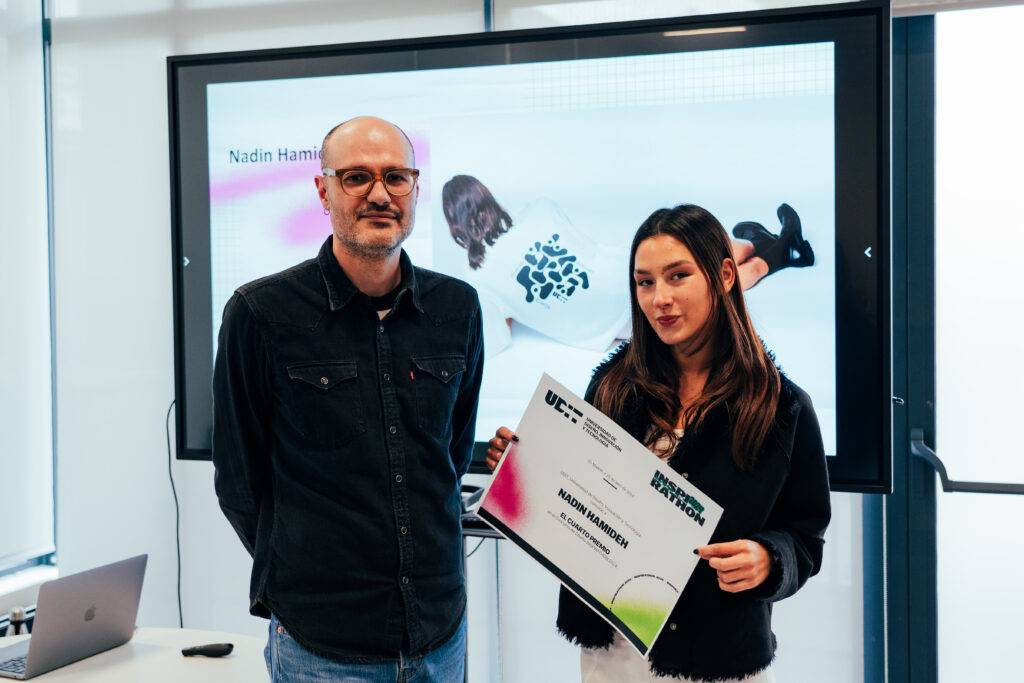Una mujer y un hombre están posando juntos mientras sostienen un certificado en un entorno de oficina.