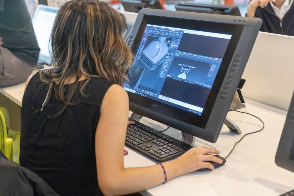 Una persona trabajando en una computadora con software de diseño gráfico.