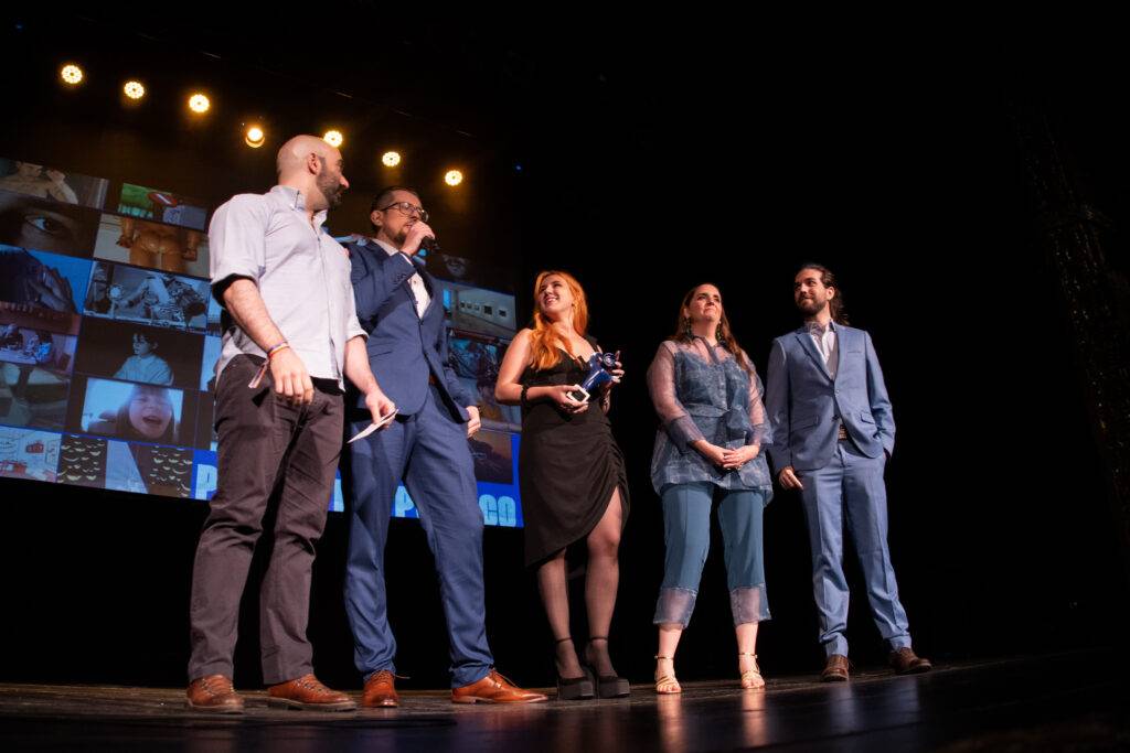 Un grupo de personas en un escenario durante un evento de premiación.