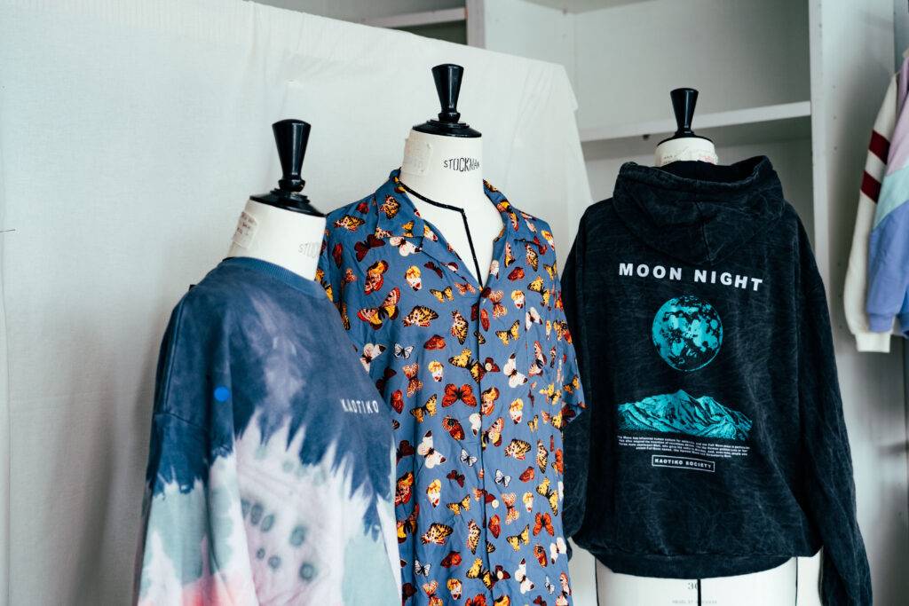 Tres maniquíes exhiben camisetas de diferentes diseños en un entorno interior.