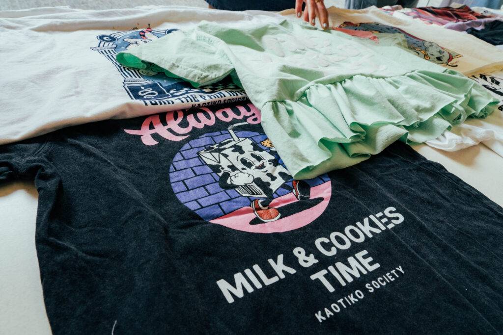 Camisas de diferentes estilos y colores están apiladas sobre una mesa.
