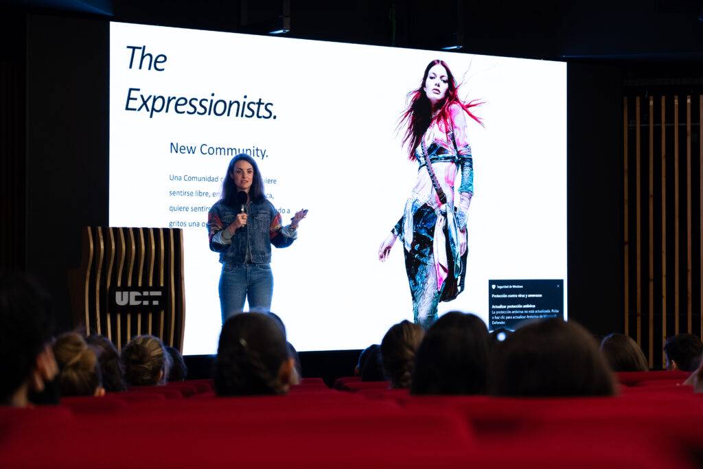 Una joven habla frente a una pantalla sobre una nueva comunidad llamada 'The Expressionists'.