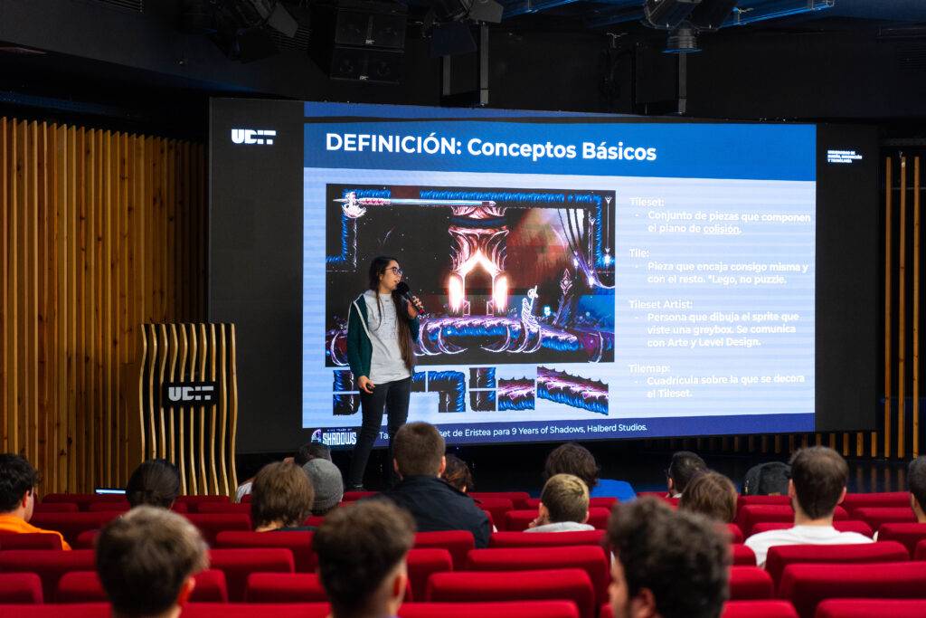 Una persona presenta un tema sobre conceptos básicos, con una pantalla que muestra contenido relacionado.