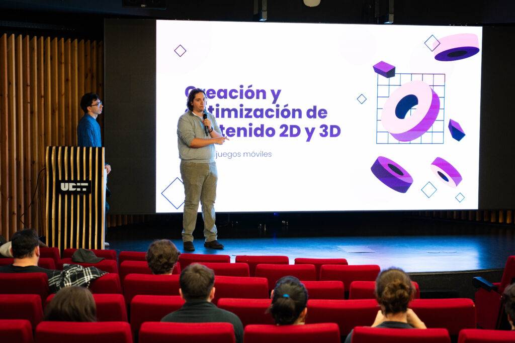 Una presentación sobre creación y optimización de contenido 2D y 3D para juegos móviles en un auditorio.