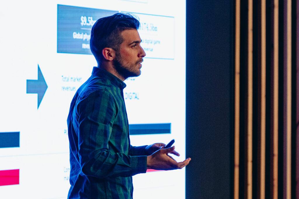 Un hombre está presentando información en una pantalla durante un evento o conferencia.