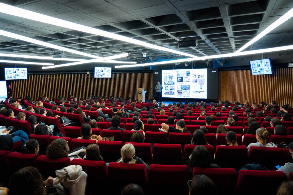 Un auditorio lleno de estudiantes asistiendo a una presentación.