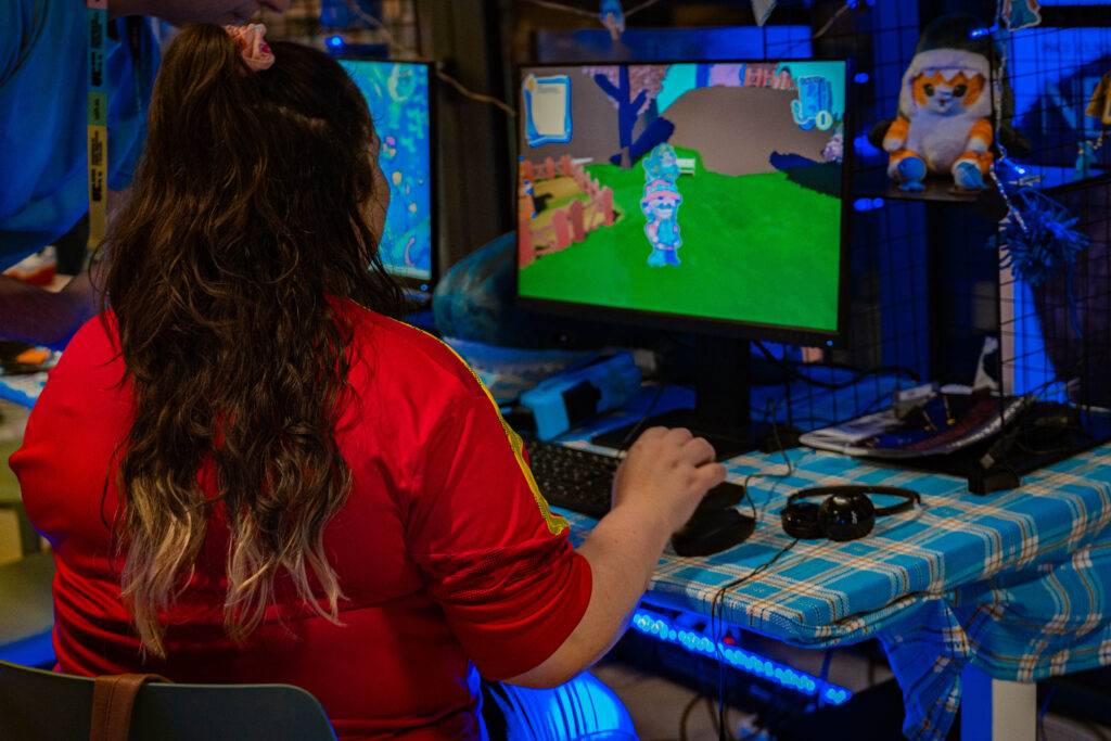 Una persona juega a un videojuego en una computadora mientras está sentada frente a ella.