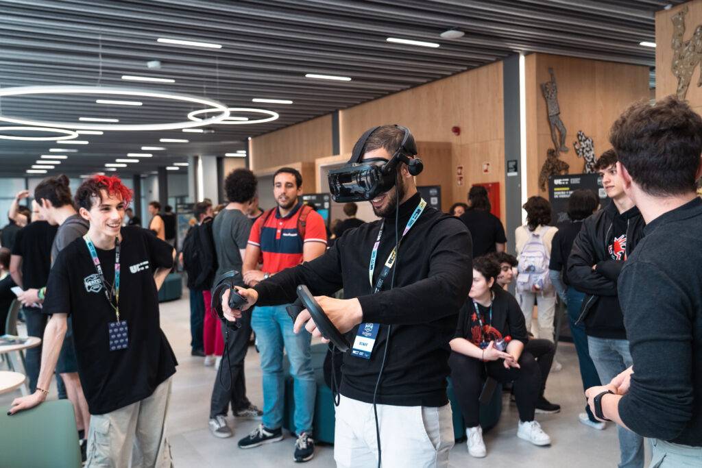 Un grupo de personas observa a un hombre que está usando un visor de realidad virtual en un evento.