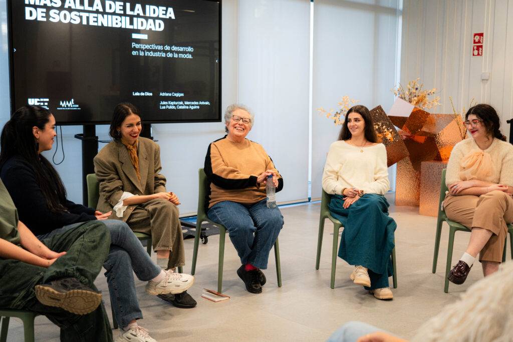 Un grupo de mujeres discutiendo sobre sostenibilidad en un evento relacionado con la industria de la moda.