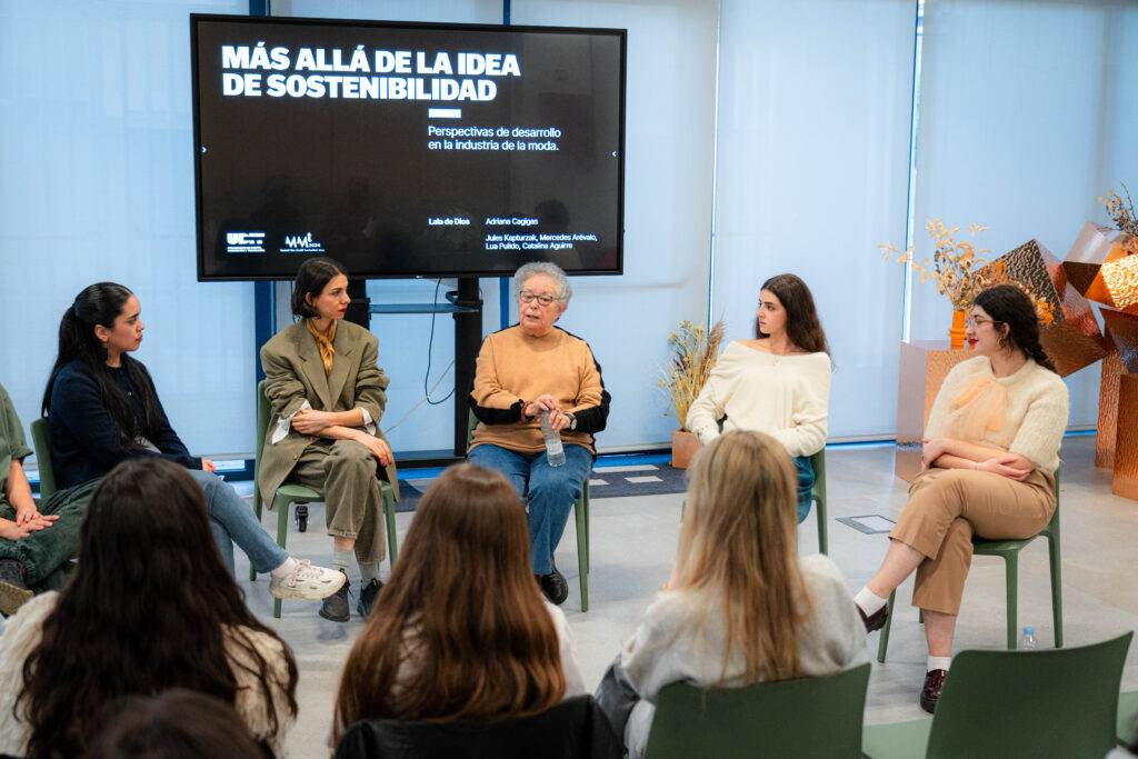 Un grupo de mujeres discutiendo el tema de la sostenibilidad en la industria de la moda.