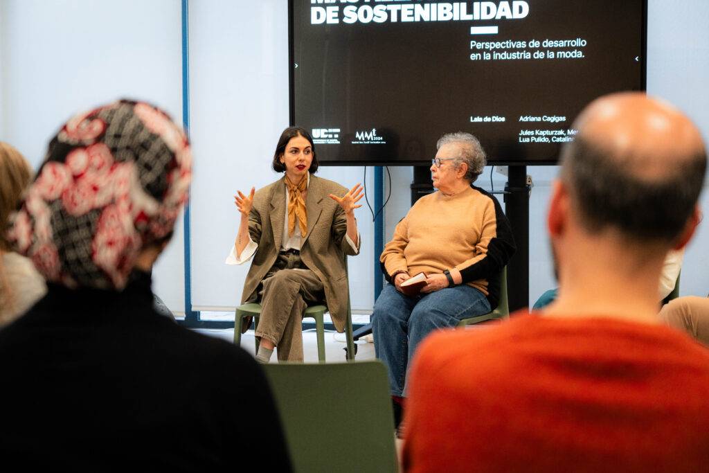 Una charla sobre sostenibilidad en la industria de la moda con varias personas en audiencia.