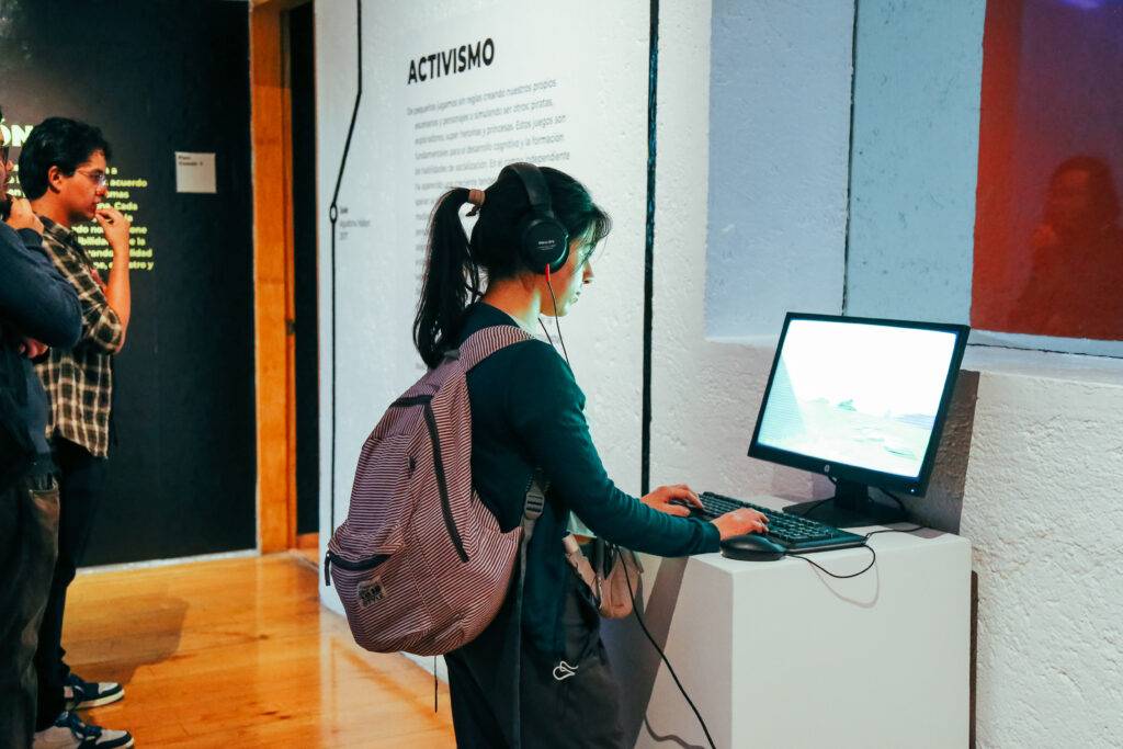 Una joven con auriculares interactúa con una computadora en una exposición sobre activismo.