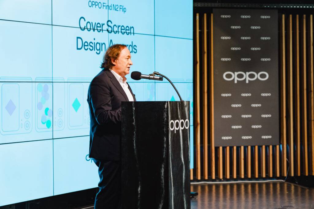 Un presentador habla en un evento de tecnología sobre el diseño de la pantalla del Oppo Find N2 Flip.