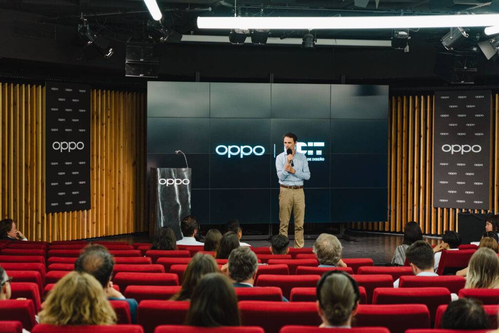 Un presentador habla frente a una audiencia en un evento de tecnología de la marca Oppo.