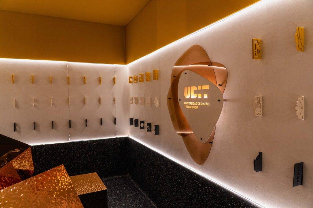 La imagen muestra una pared decorativa con piezas de diseño variado y un letrero destacado en el centro.