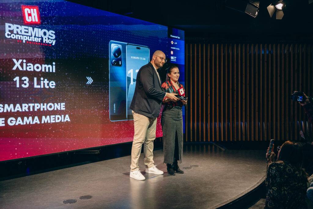 Una pareja de presentadores entrega un premio en un evento de tecnología.
