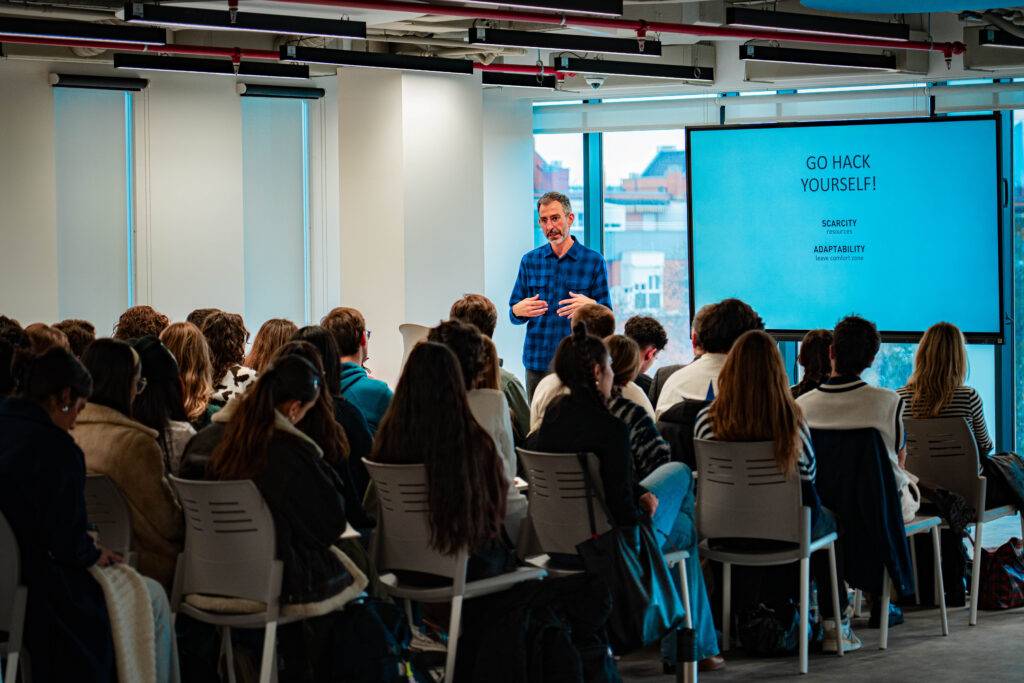 Un ponente habla frente a una audiencia en un entorno moderno y acogedor.