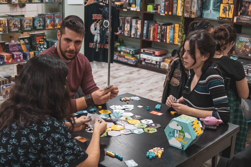 Un grupo de personas juega a juegos de mesa en una tienda especializada.